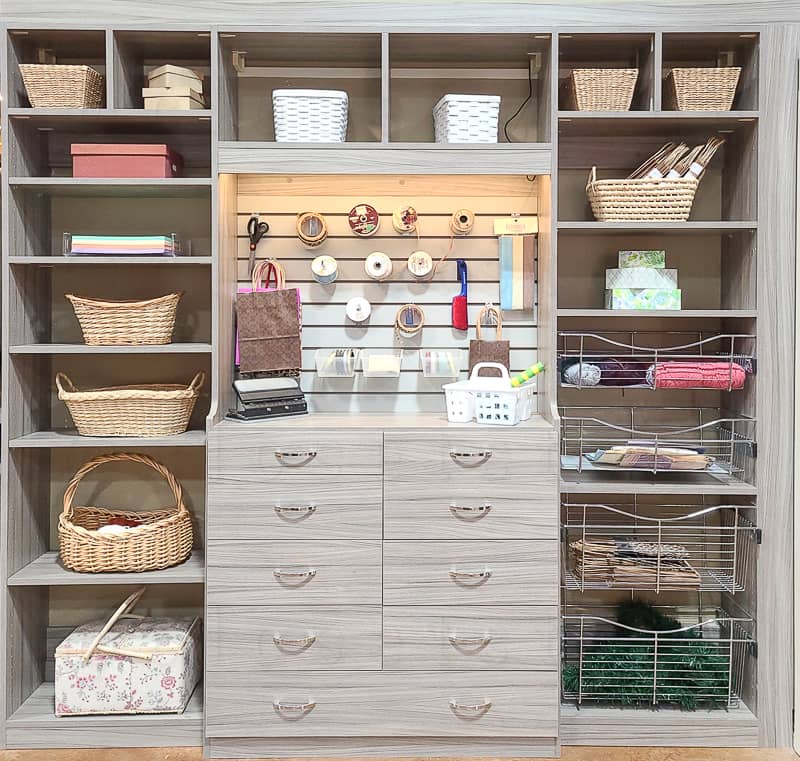Reach in craft closet with drawers, shelves and baskets.